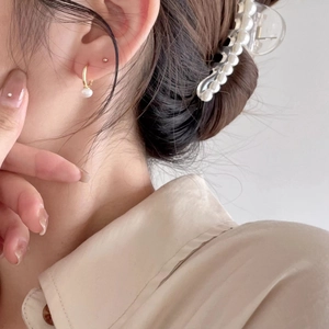 Elegant gold pearl hoop earring shown on a model with close-up profile detail