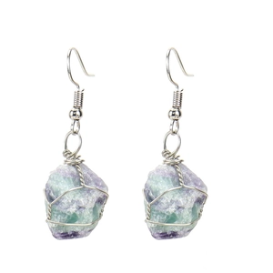 Close-up of handmade silver wire wrapped natural fluorite crystal earrings in purple and green