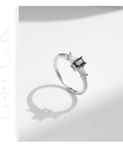 Macro detail of silver ring featuring a gradient green-purple rectangular crystal gem