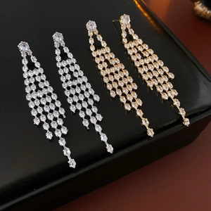 Close-up of gold and silver plated tassel earrings with sparkling zircon stones