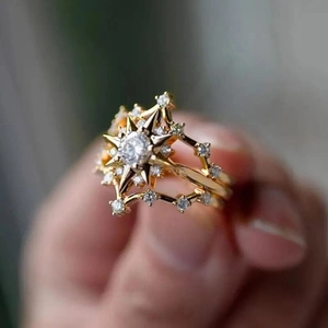 Detailed macro view of gold sunburst starburst ring with a sparkling round zircon stone