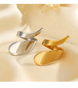 Detailsicht auf goldene und silberne klobige geometrische Ringe auf Seidenstoff