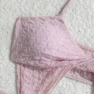 Detailaufnahme des blassrosa Bikini-Oberteils mit gewelltem Strukturstoff und Trägern