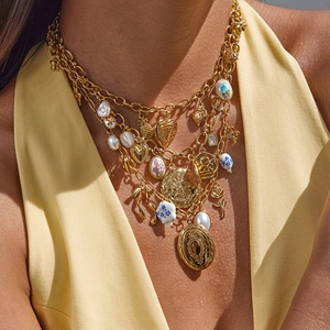 Détail du collier doré multicouche avec perles en céramique et breloques vintage sur modèle