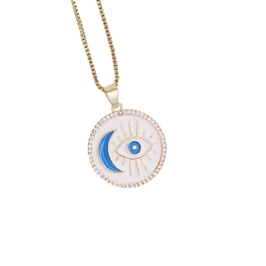 Macro view of golden pendant featuring blue evil eye and moon motif with zircon crystals