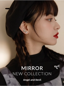 Close-up of angel and demon wing earrings with pearls on a female model