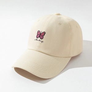 Detail of pink butterfly embroidery and be the change text on a beige cotton baseball cap