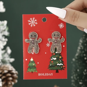 Detailed view of gingerbread man earrings with rhinestones on a festive holiday card