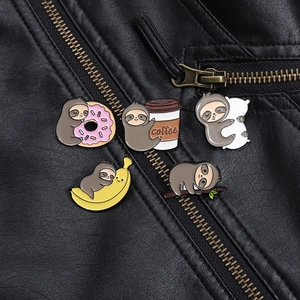 Close-up of five cartoon sloth enamel pins featuring coffee and donuts on a leather jacket