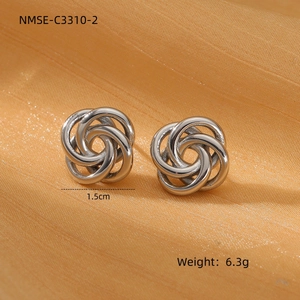 Macro detail of silver twisted hoop earrings with 1.5cm diameter on silk fabric