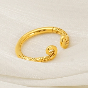 Close-up of golden sun-wukong style ring with detailed carvings on white silk
