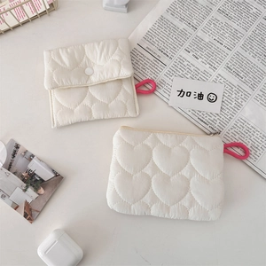 Close-up of heart quilted mini pouch bags with white buttons and pink lanyards