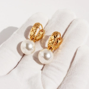 Elegant gold U-shaped hoop earrings with quilted pattern and white pearl drop accents