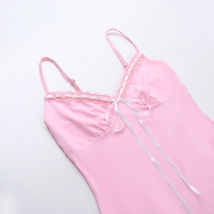 Dettaglio di canotta in seta rosa con bordo in pizzo bianco e decorazione con fiocco