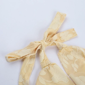 Dettaglio ravvicinato del tessuto jacquard floreale 3D giallo pallido e lacci
