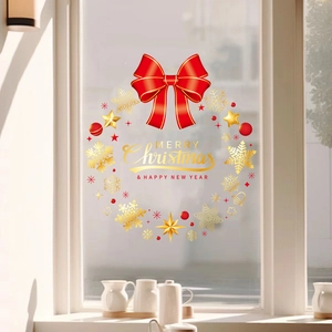 Detail of Christmas window sticker with red bow, golden snowflakes and festive lettering