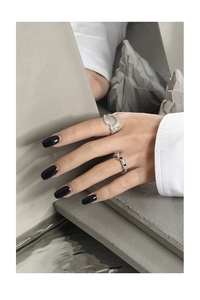 Dettaglio di anelli in argento S925 con texture lavica e piccolo cuore nero