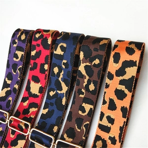 Close-up of leopard print handbag straps in purple, pink, blue, brown, and orange colors