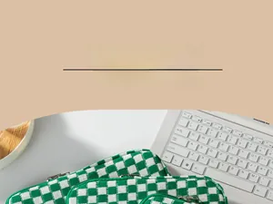 Close-up of green and white checkered knit laptop sleeve with metal zipper detail