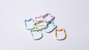 Detail of cat-shaped spring ring hooks in assorted macaron colors with matte finish