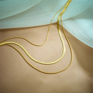 Layered gold snake and herringbone chain necklaces made of premium titanium steel