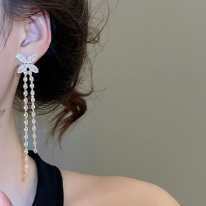Detail of long tassel butterfly earrings with sparkling cubic zirconia on a female model