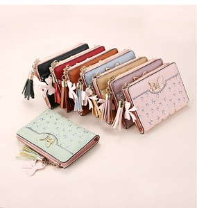 Detail of floral women's small wallet with golden butterfly clasp and tassel charm