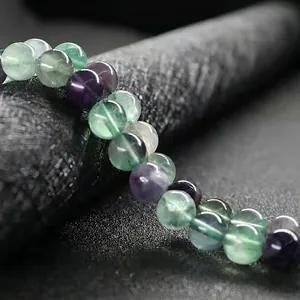 Detailed macro shot of natural purple and green fluorite beads with translucent texture