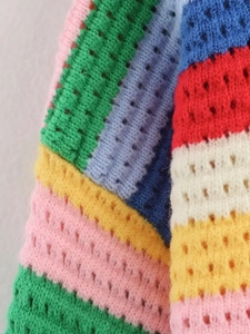 Gros plan détaillé du tissu en maille crochetée arc-en-ciel avec franges colorées