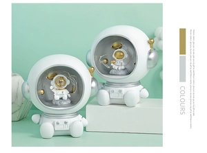 Detail view of astronaut night light ornaments with glowing star strings and clear helmets