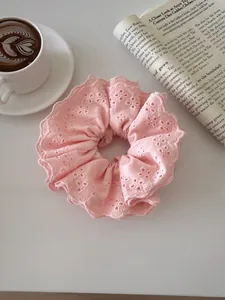 Detail of pink lace scrunchie with hollow embroidery and fine floral eyelet patterns