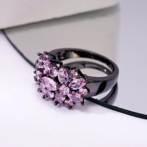 Macro detail of floral cluster ring with pink marquise stones on black metal band