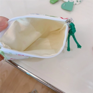 Detailed view of floral cotton pouch with smooth zipper and green rope puller charm