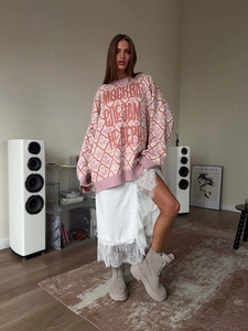 Pink argyle knit sweater with Moscow slogan paired with white lace skirt and boots