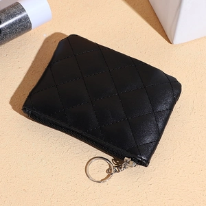 Detailed macro view of black quilted faux leather coin purse with silver zipper and keychain
