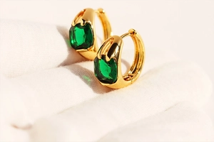 Macro shot of square emerald green zircon stone set in vintage gold hoop earring