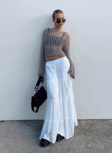 Detail of layered white maxi skirt paired with grey hollow knit long sleeve top