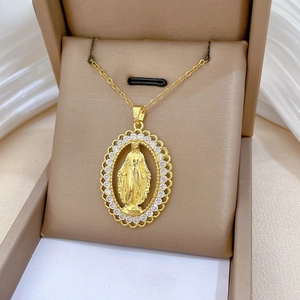 Detail of gold oval Virgin Mary pendant with cubic zirconia and lace filigree borders