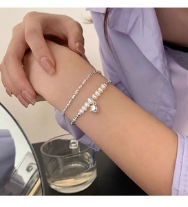 Macro shot of s925 silver lily of the valley bracelet with freshwater pearls and bell charm
