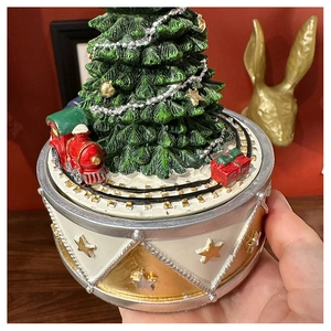 Detailed close-up of a rotating Christmas tree music box with a red toy train on base