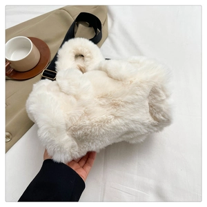 Close-up of white plush tote bag on white fabric with casual lifestyle accessories
