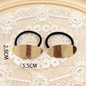 Detailed view of large gold oval alloy hair tie with dimensions 5.5cm by 2.5cm