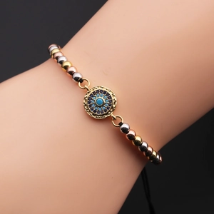 Macro detail of tricolor beads and evil eye charm on an adjustable bracelet