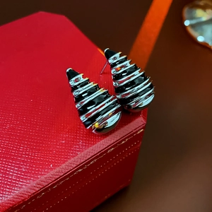 Close-up of teardrop vintage earrings in black and white enamel on a red textured box
