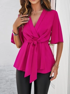 Détail du haut en mousseline rose foncé avec col en V et ceinture nouée à la taille