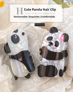 Close-up of cute panda hair claws in black and white finish with a pink flower detail