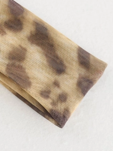 Detailed macro view of sheer brown leopard print mesh fabric with translucent texture