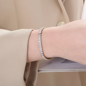 Gros plan d'un bracelet tennis doré avec zircons rectangulaires porté au poignet