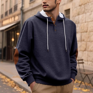 Men's navy hooded sweatshirt with brown elbow patches and button detail in street setting