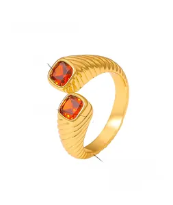 Macro detail of 18K gold plated copper ring featuring geometric orange zircons